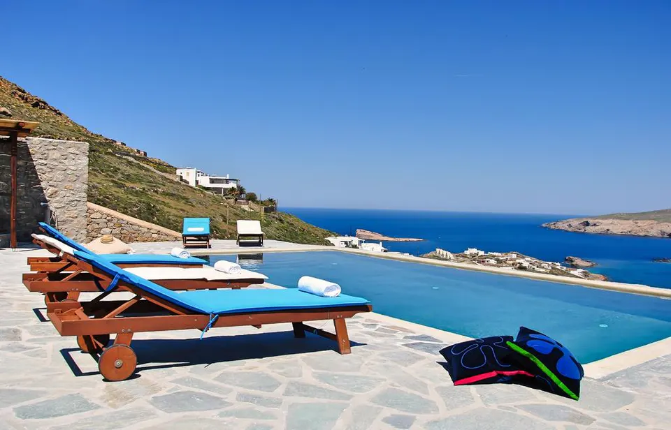 Pool with sun beds and a view of the sea and the coast
