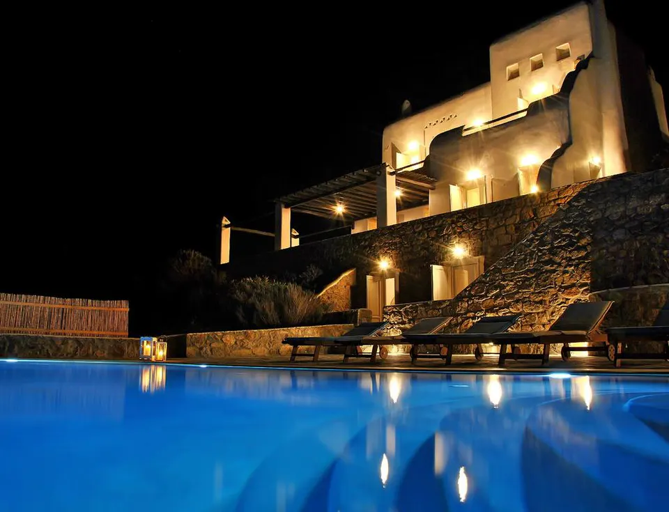 The villa and pool lit up at night