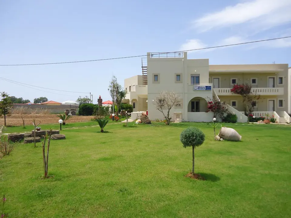 Apartment building seen across the lawn, with a small tree in the foreground
