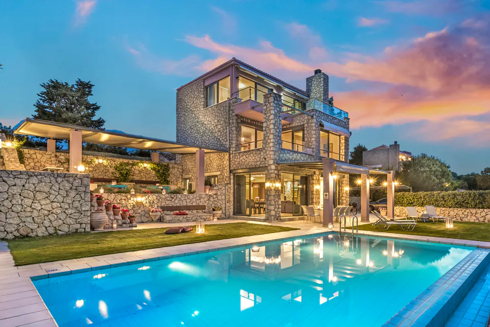 Stone villa and pool at dusk