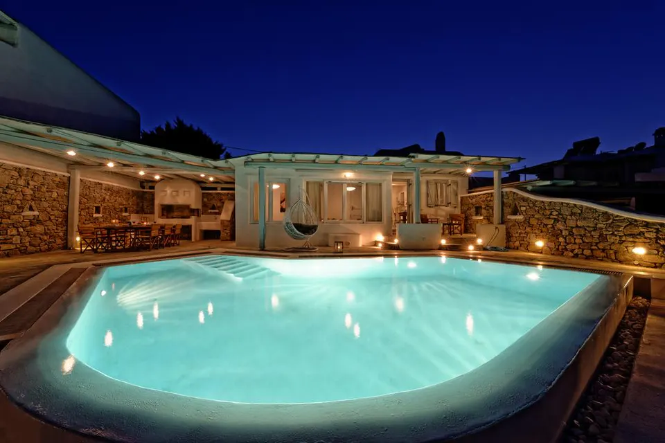 Pool and villa lit up at night