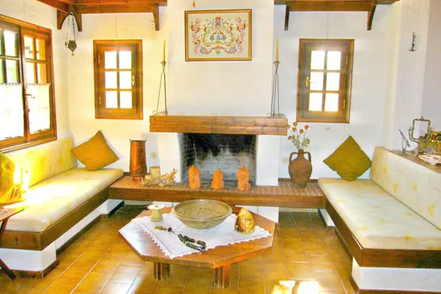 Fireplace between two built-in sofas with yellow cushions
